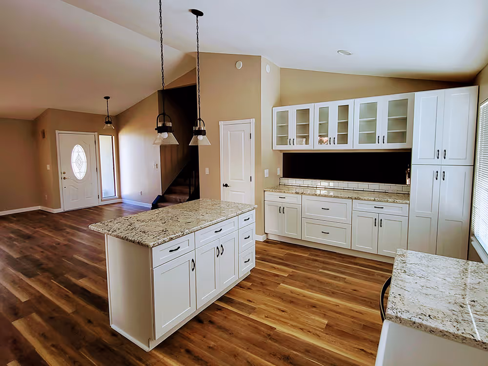 Home renovation project showing a newly installed kitchen with quartz countertops and island.
